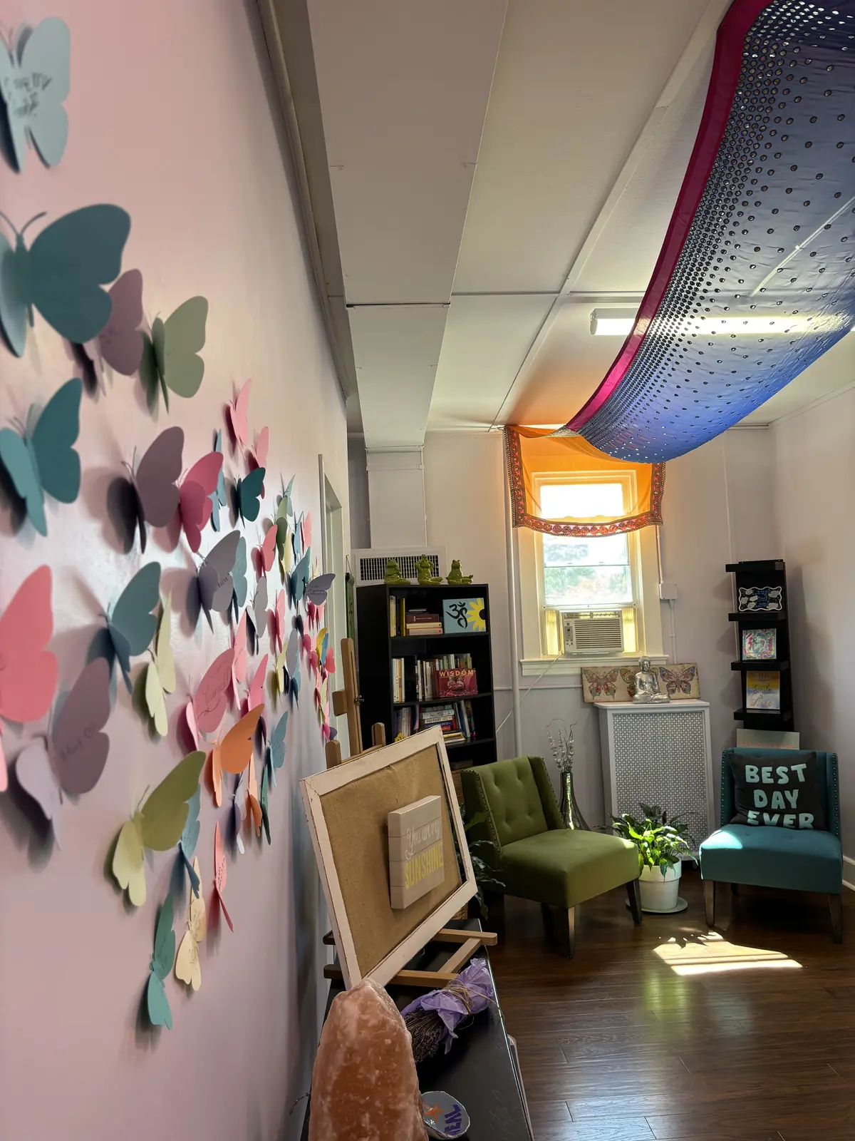A butterfly art wall beside a reading area in the studio