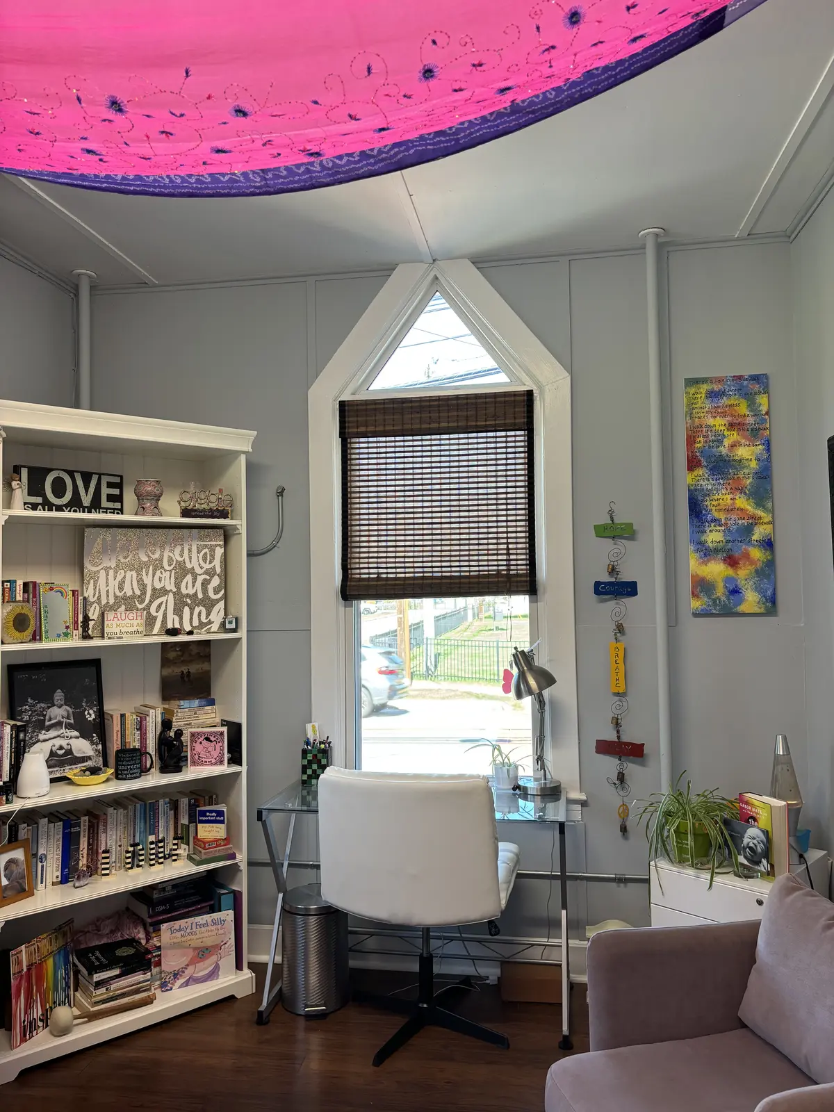 Therapy room with an arched window and bookshelf at the Center for Mind Body Balance